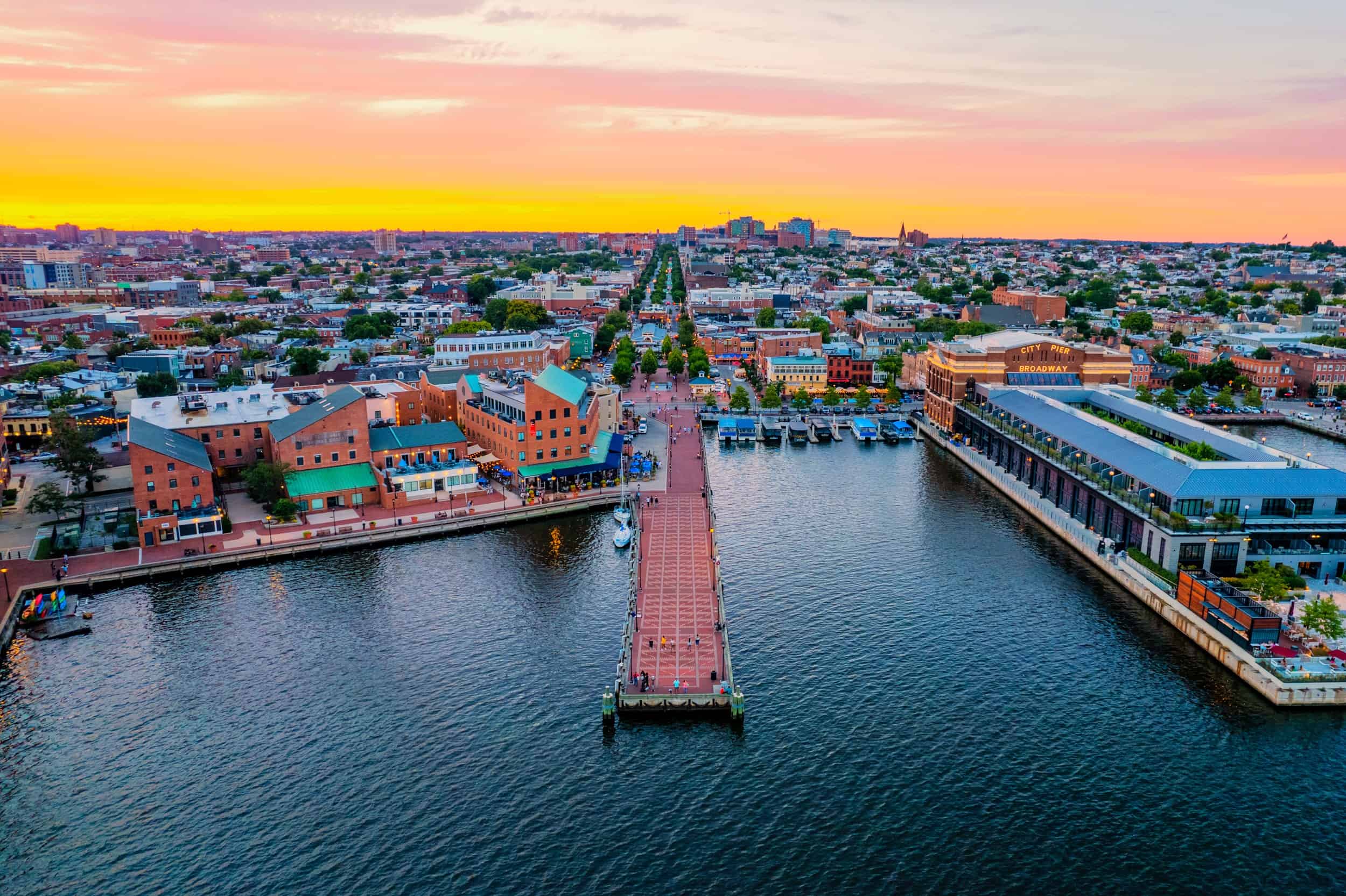  An aerial photograph of the Fell's Point waterfront in Baltimore, in June 2022 at sunset.