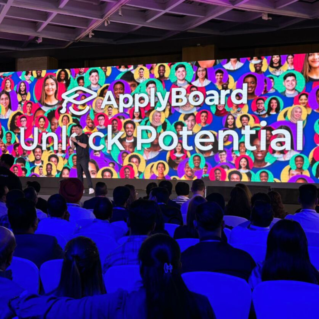 A colourful slide on-stage at TRW with the simple words: ApplyBoard. Unlock Potential.