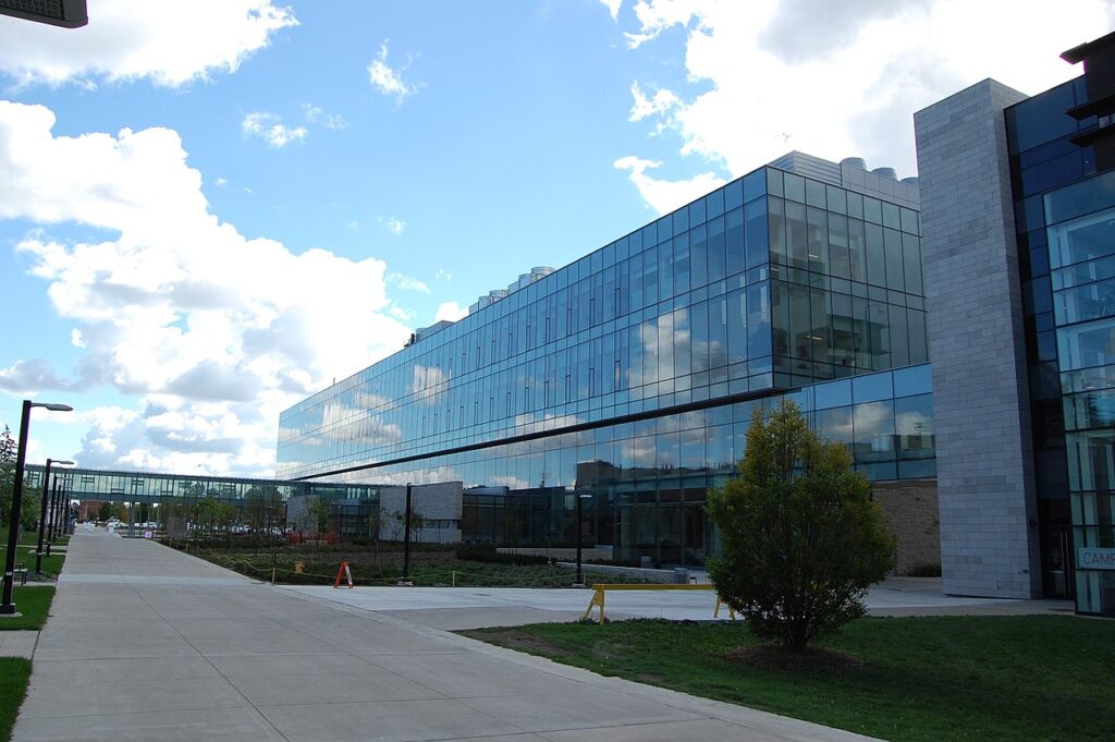 A wide concrete walkway next to mirror-glass academic buildings on Brock University's campus.